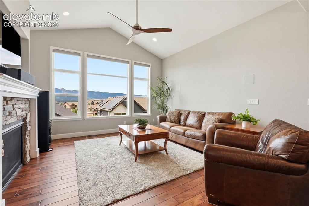 Image 13 of 47: Spacious living area featuring a vaulted ceiling and wood-finish flooring