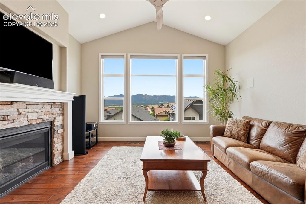 Image 14 of 47: Living area featuring vaulted ceilings, recessed lighting, and rich wood-fi