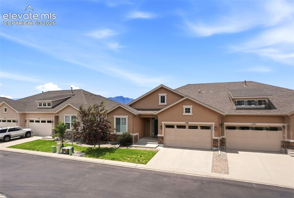 Image 2 of 47: Exterior featuring stucco siding with stone accents, a multi-car garage, an