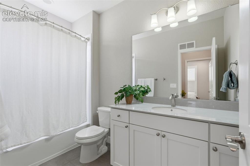 Image 21 of 47: Bathroom featuring a single-sink vanity with white cabinetry, a light-toned