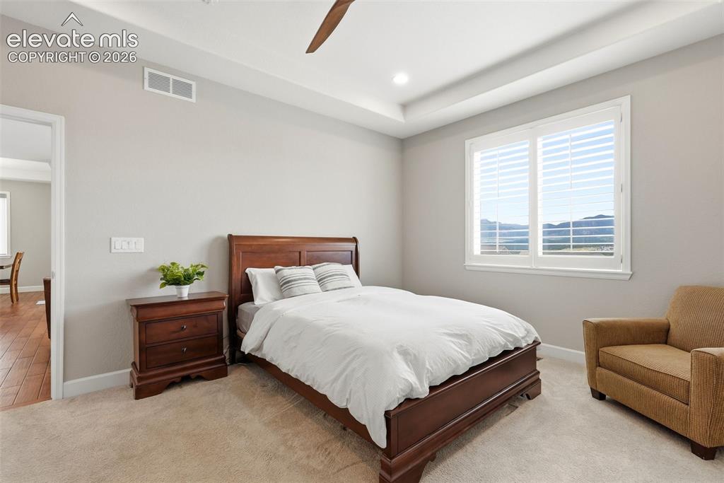 Image 25 of 47: Spacious room featuring a tray ceiling, recessed lighting, and a ceiling fa