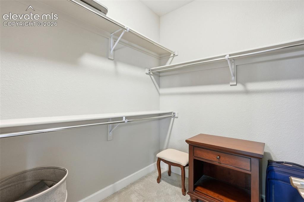 Image 29 of 47: Walk-in closet featuring white wire shelving and hanging rods