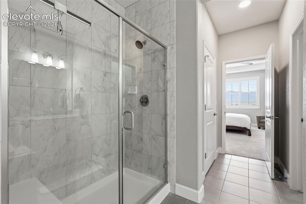 Image 30 of 47: Walk-in shower featuring glass enclosure, subway tile surround, built-in sh