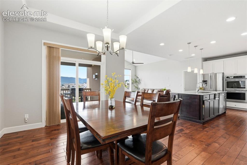 Image 4 of 47: Open-concept living area with dark wood-finish flooring, recessed lighting,