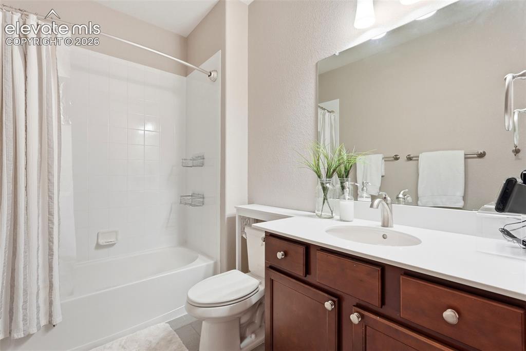 Image 44 of 47: Full bathroom featuring a single vanity with wood-finish cabinetry, a white