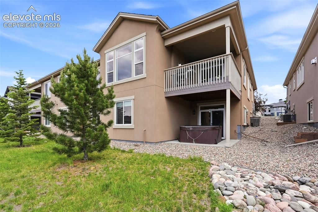 Image 46 of 47: Rear stucco exterior with an upper-level balcony featuring white railings