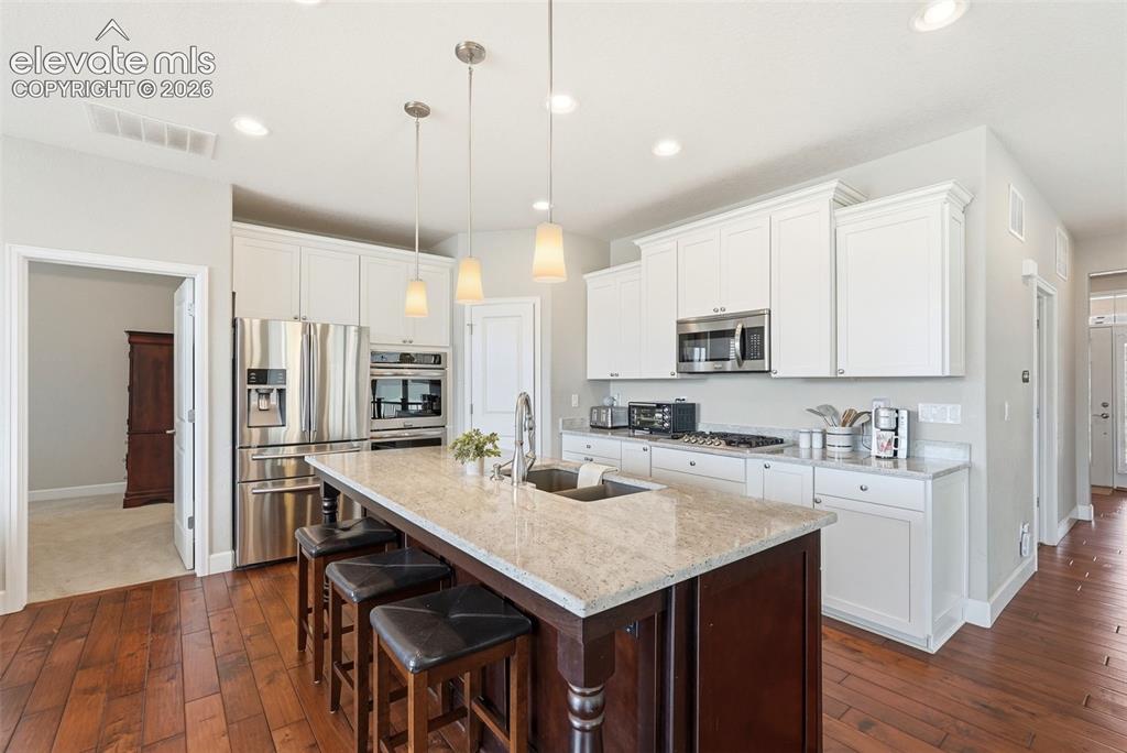 Image 6 of 47: Open-concept kitchen featuring an oversized island with seating, stainless 