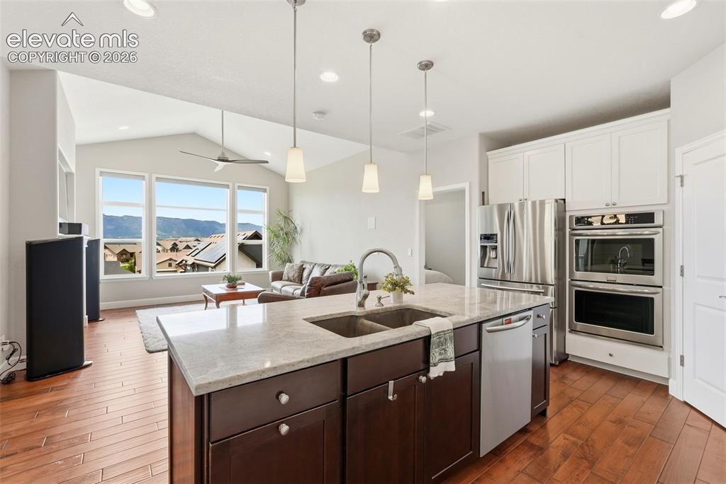 Image 7 of 47: Kitchen island with dual basin sink, integrated dishwasher, and pendant lig
