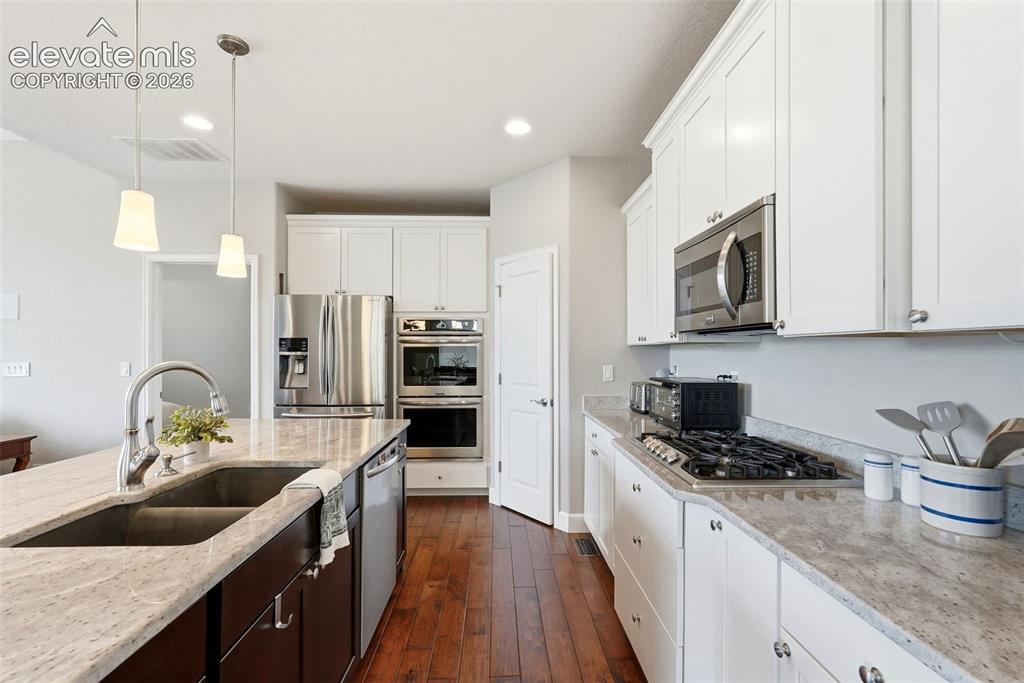 Image 8 of 47: Kitchen featuring light-toned countertops, white upper and lower cabinetry,