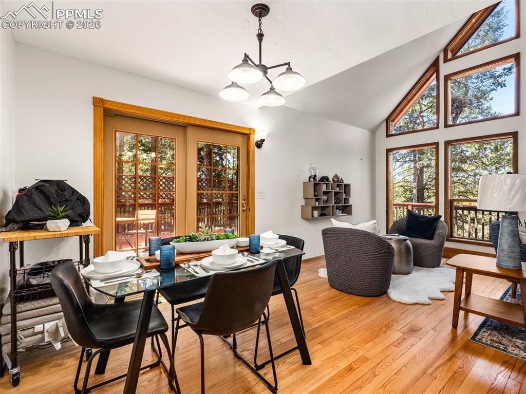 Image 11 of 37: Dining area with lofted ceiling, light wood-style flooring, and hanging lig