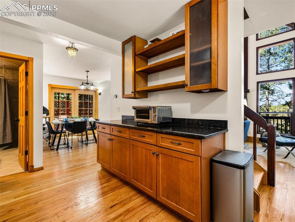 Image 12 of 37: Kitchen featuring wood finish cabinets, open shelves, light wood finished f