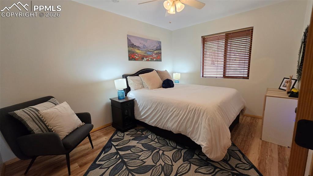 Image 15 of 38: Bedroom featuring wood-finish flooring, a ceiling fan with light fixture, a