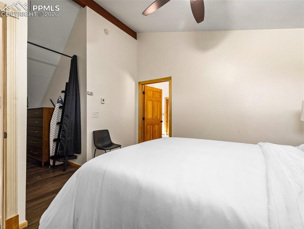 Image 23 of 38: Bedroom featuring vaulted ceiling, a ceiling fan, and dark wood-type floori
