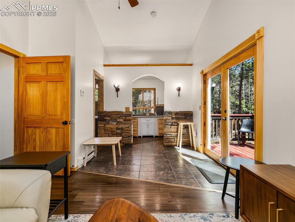 Image 25 of 38: Foyer entrance featuring dark wood-style flooring, vaulted ceiling, french