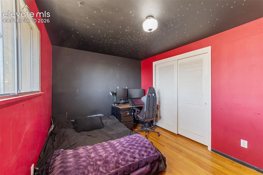 Image 24 of 50: Room featuring wood-finish flooring and a black ceiling with star-effect li