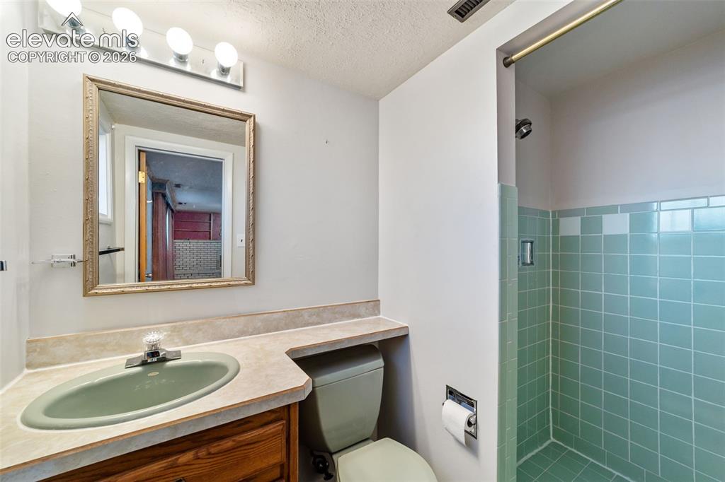 Image 34 of 50: Bathroom featuring a built-in wood-finish vanity with an integrated sink an