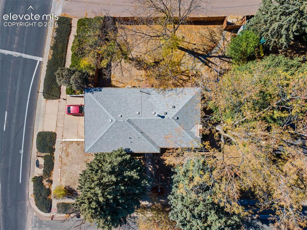 Image 37 of 50: Gable roof home with a gray shingle roof, chimney, and extended driveway