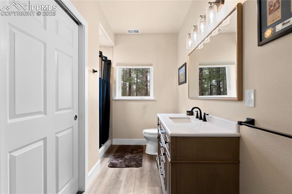 Image 45 of 47: Bathroom with stone counters and closet space in detached garage
