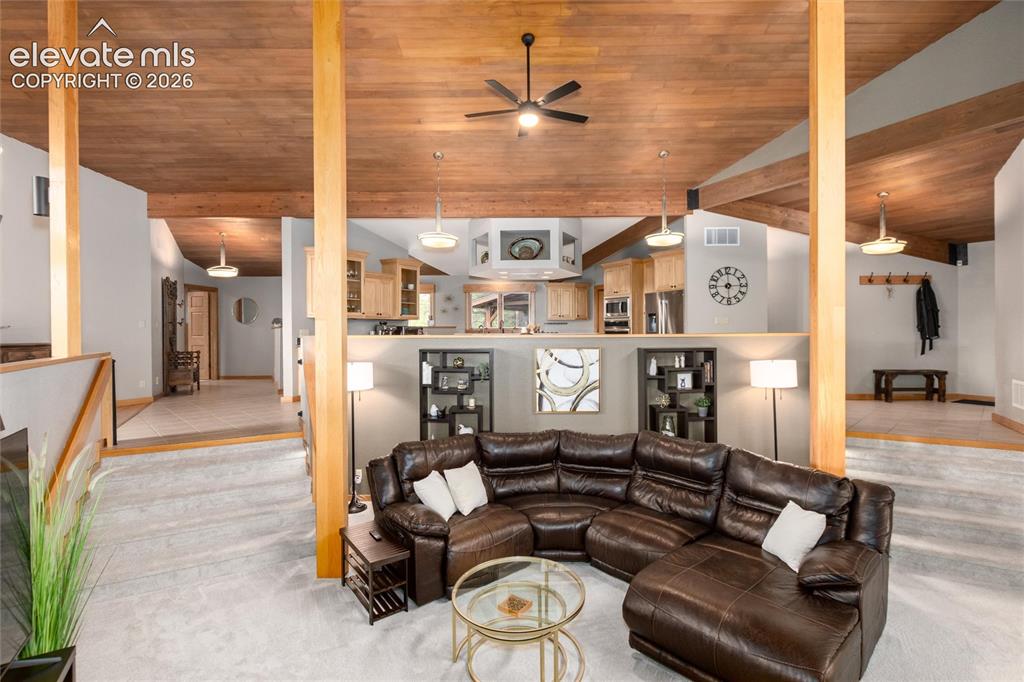 Image 15 of 50: Vaulted wood-finish ceilings with exposed beams and ceiling fans