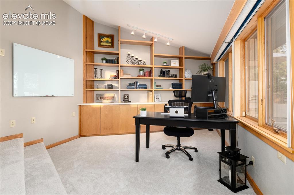 Image 17 of 50: Light-toned carpeted room featuring a built-in wood shelving unit, wood-fra