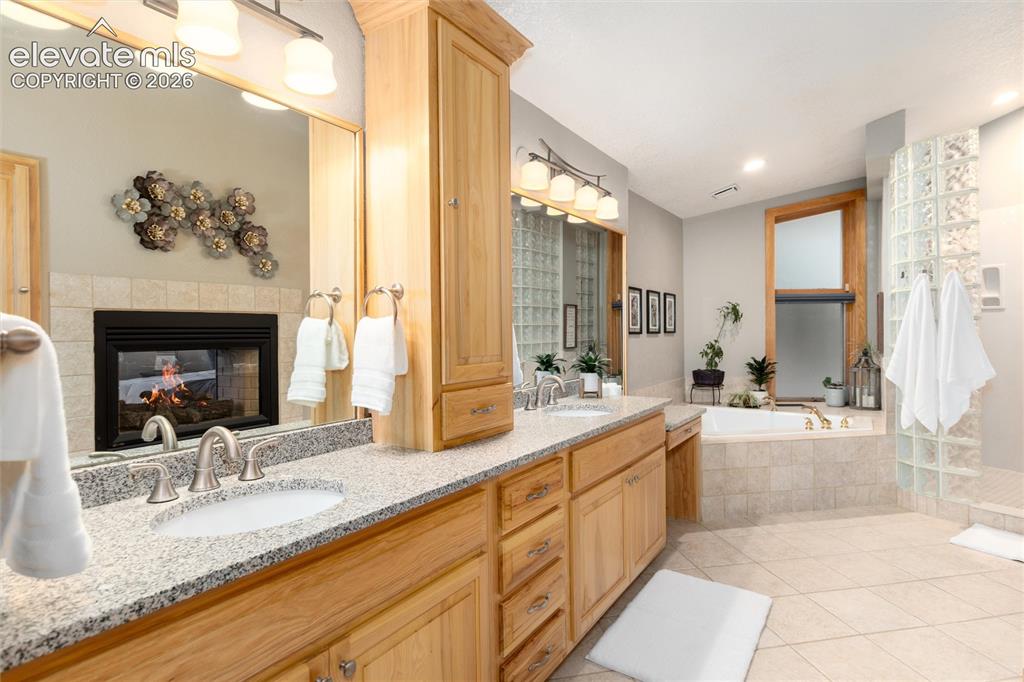Image 21 of 50: Spacious bathroom featuring a dual vanity with granite countertops, built-i