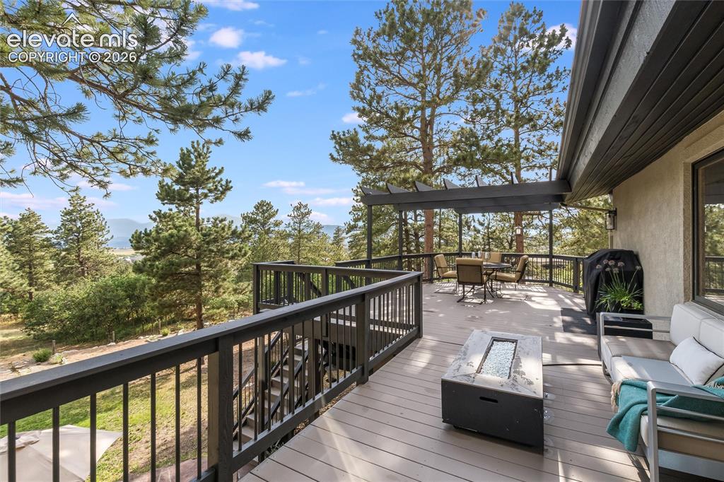 Image 31 of 50: Expansive outdoor deck featuring wood-finish flooring, dark-stained railing