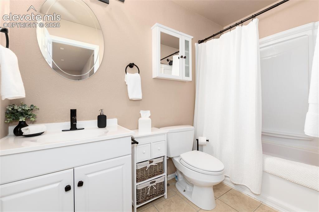 Image 40 of 50: Bathroom featuring a white vanity with integrated sink, black single-handle
