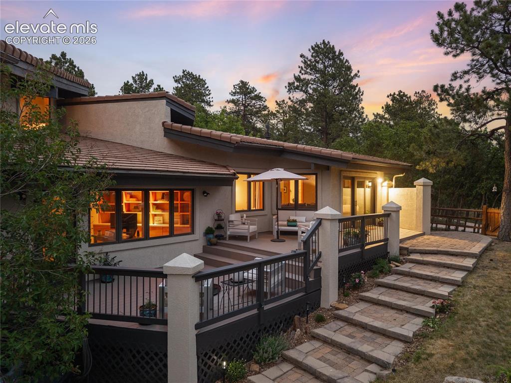 Image 44 of 50: Multi-level rear exterior featuring a composite deck, stucco siding, and a 