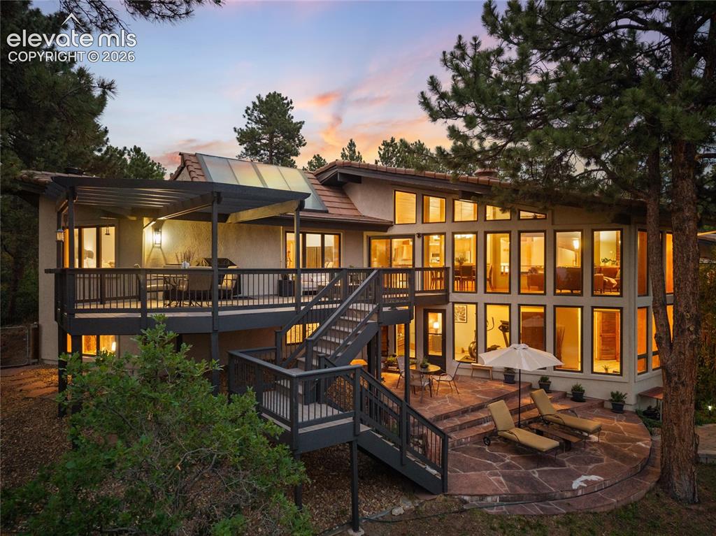 Image 45 of 50: Multi-level rear exterior featuring a large upper deck with a pergola, a cu