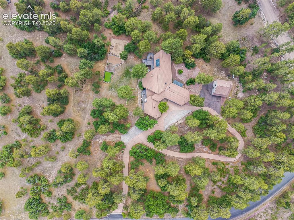 Image 48 of 50: Expansive property featuring a multi-wing residence with a tan roof, a long
