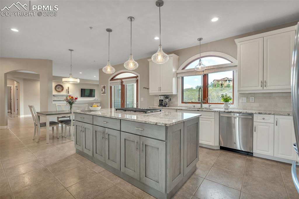 Image 10 of 49: Kitchen with appliances with stainless steel finishes, a sink, arched walkw
