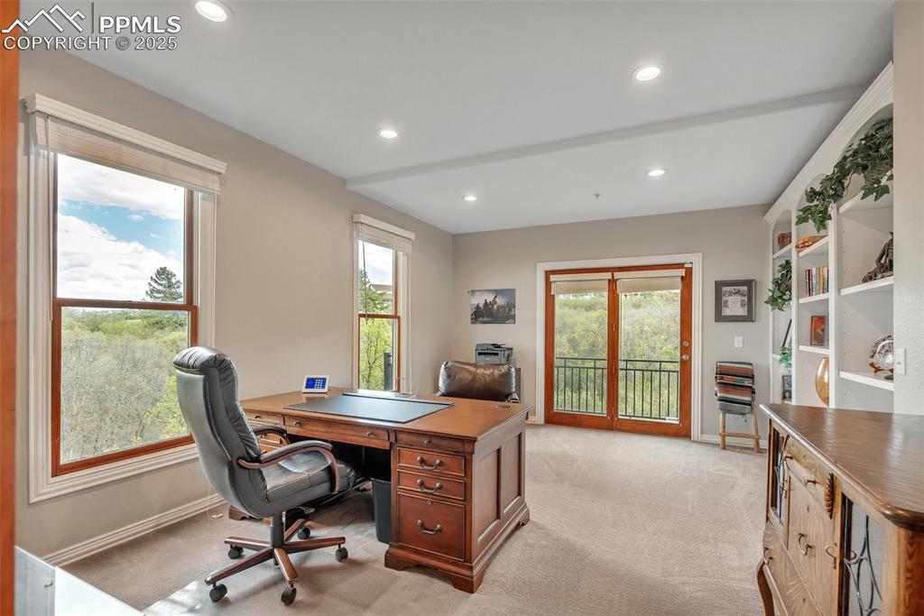 Image 12 of 49: Office space featuring light carpet, baseboards, plenty of natural light, a