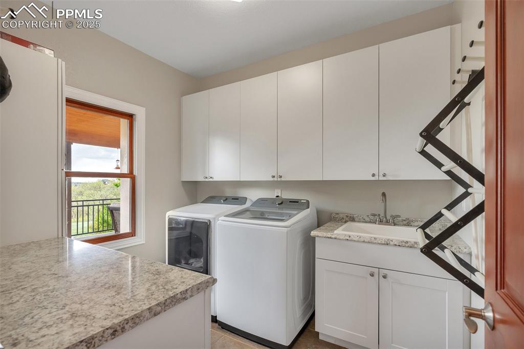 Image 13 of 49: Laundry area with cabinet space and separate washer and dryer