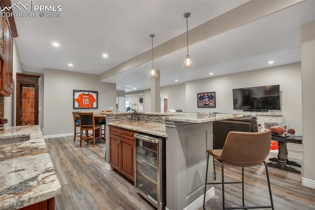 Image 14 of 49: Kitchen with beverage cooler, light wood-style floors, open floor plan, a k