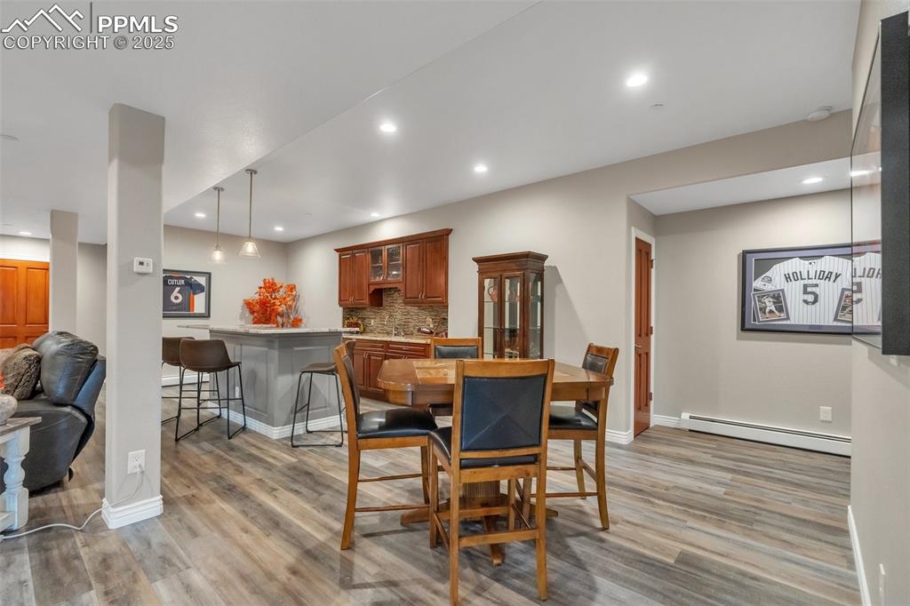 Image 17 of 49: Dining area featuring a baseboard radiator, light wood-style floors, basebo