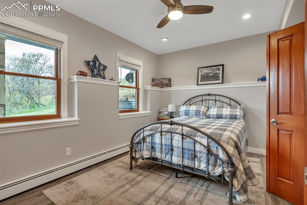 Image 19 of 49: Bedroom with a baseboard radiator, multiple windows, recessed lighting, a c