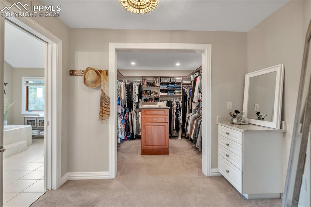 Image 28 of 49: Walk in closet featuring light carpet