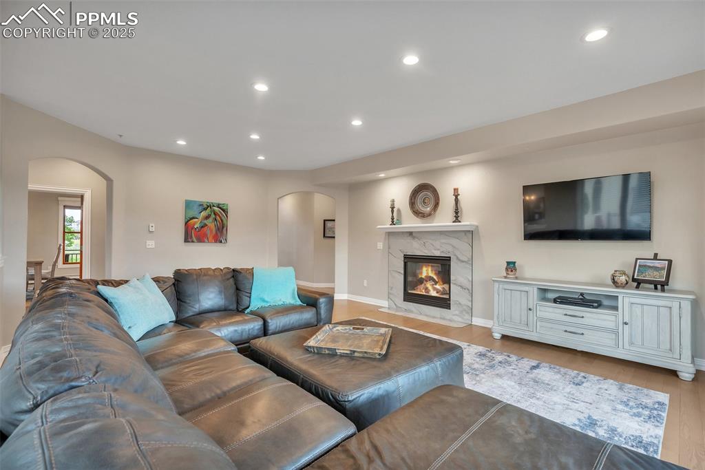 Image 3 of 49: Living area with arched walkways, light wood-style floors, recessed lightin