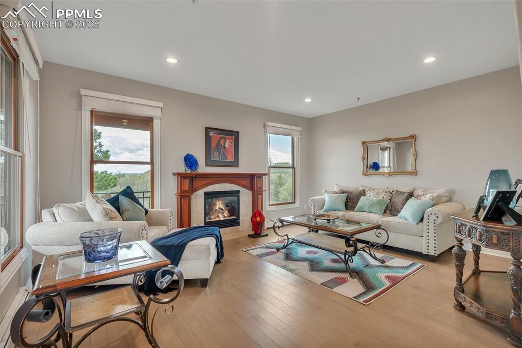 Image 6 of 49: Living area featuring recessed lighting, a tile fireplace, and wood finishe