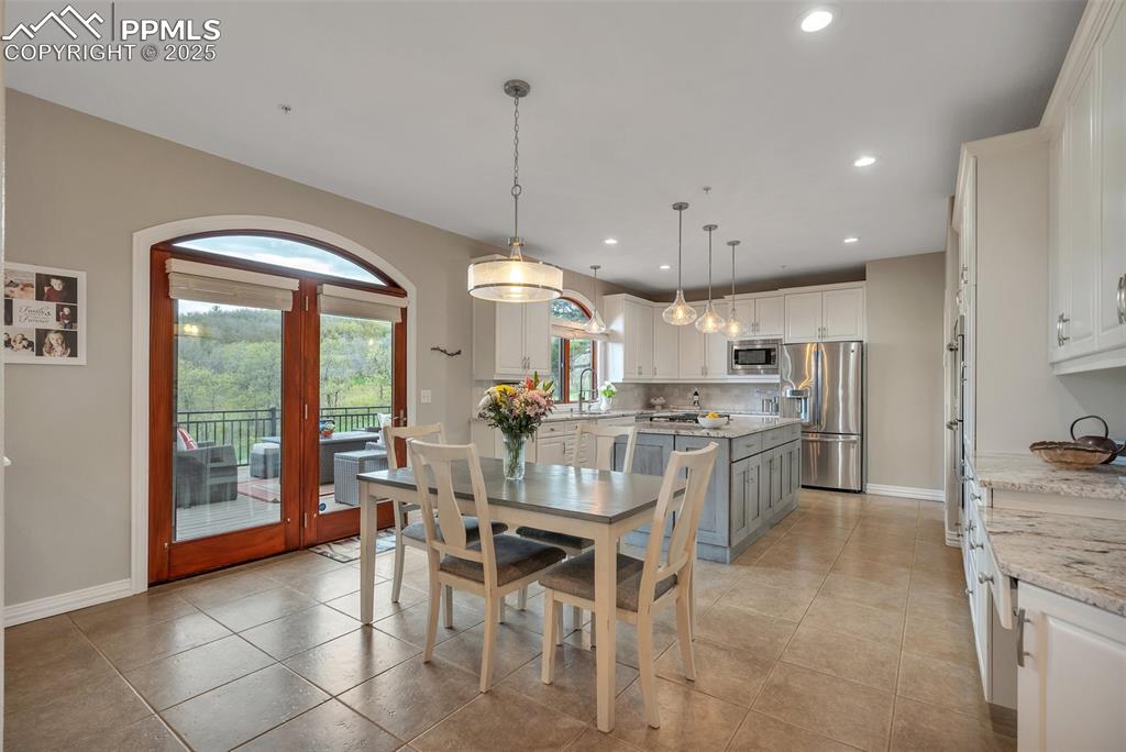 Image 8 of 49: Dining room with recessed lighting, baseboards, and light tile patterned fl