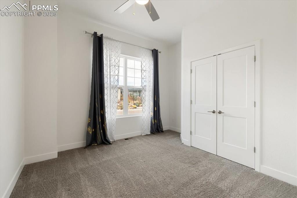 Image 4 of 31: Unfurnished bedroom featuring carpet floors, baseboards, a ceiling fan, and
