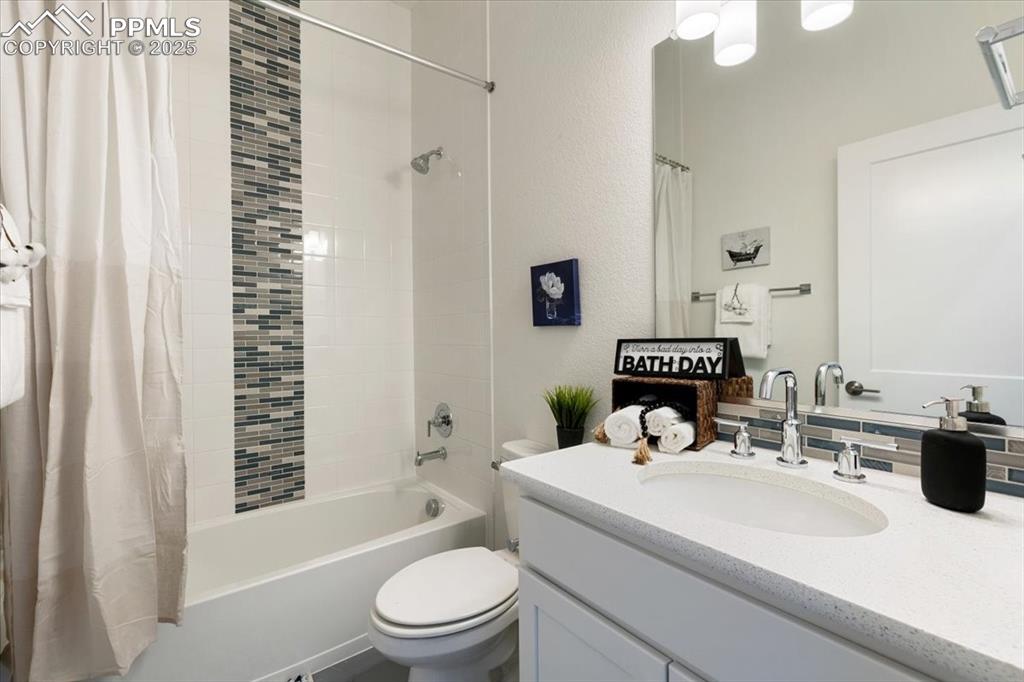 Image 5 of 31: Full bath with toilet, vanity, and shower / bath combo with shower curtain