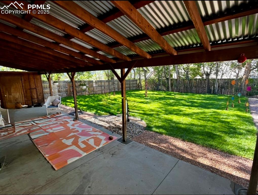 Image 22 of 28: Backyard during the summer, trees full of foliage and lush green grass