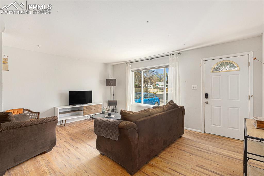 Image 4 of 28: Bright and welcoming living room featuring hardwood floors