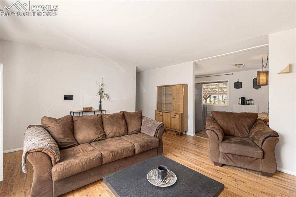 Image 5 of 28: Bright and welcoming living room featuring hardwood floors