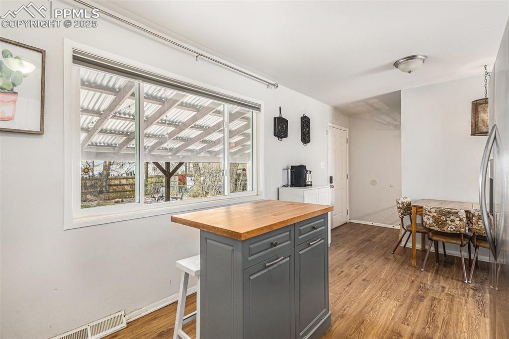 Image 9 of 28: Kitchen with hardwood floors and dining space