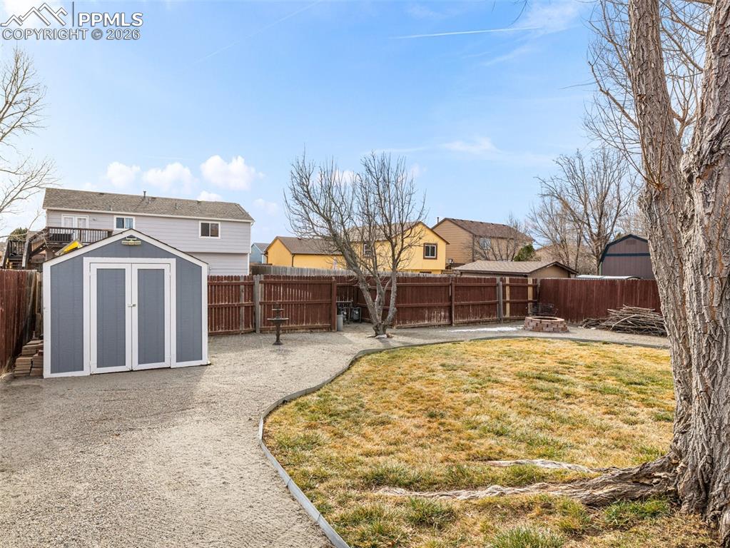 Image 29 of 31: Fenced backyard with a storage unit 