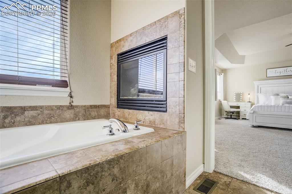 Image 31 of 49: Soaking tub with a fireplace. Yes please. 