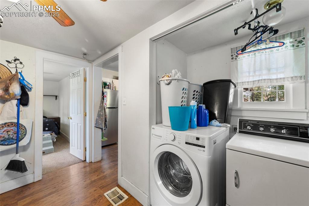 Image 12 of 31: Laundry room featuring separate washer and dryer and wood finished floors