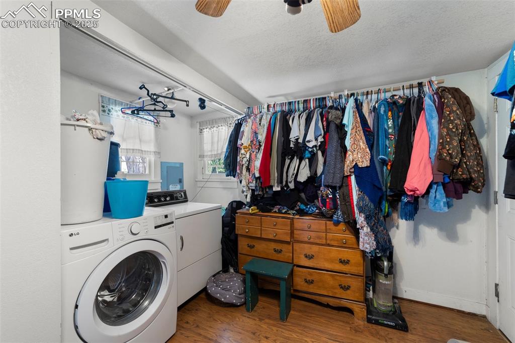 Image 13 of 31: Laundry area with wood finished floors, a ceiling fan, a textured ceiling,